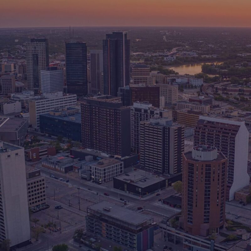 An aerial view of downtown Winnipeg's skyline with an Indigo semi-transparent overlay